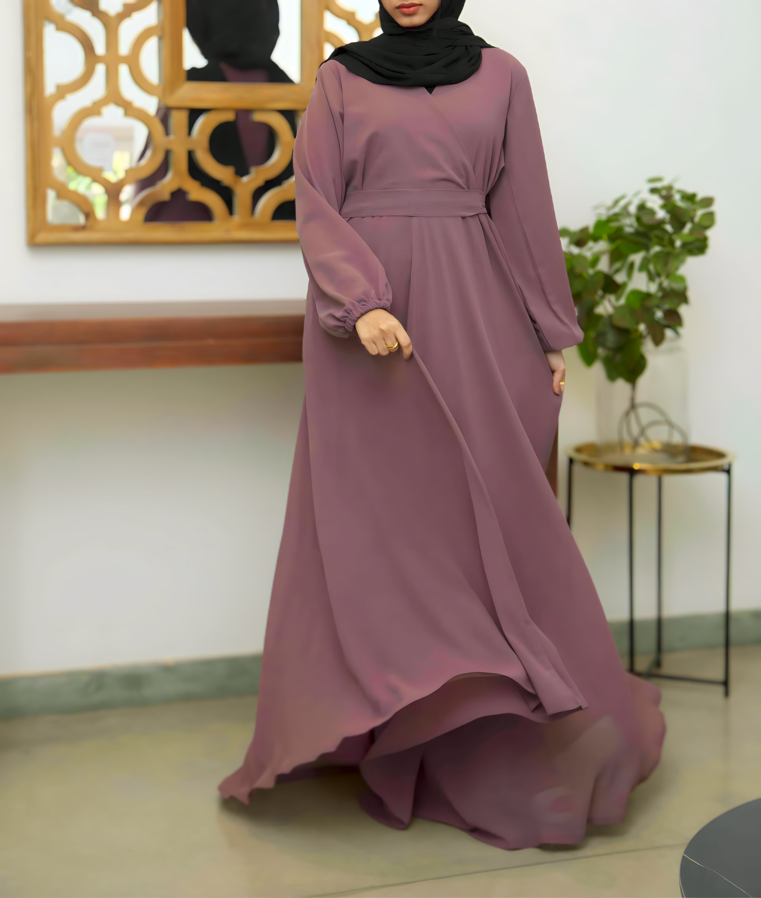 A flowing wrap-style abaya dress featuring a belted waist and elastic cuffs from the 2026 collection.
